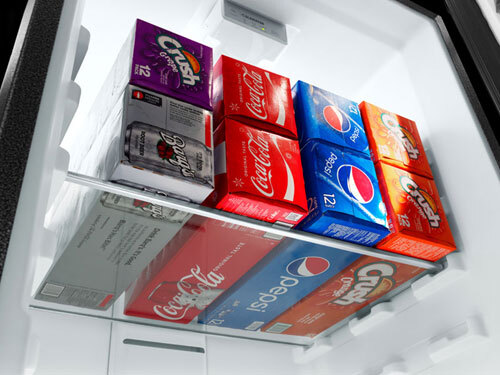 Garage refrigerator filled with party drinks, holiday trays, and food prep items.