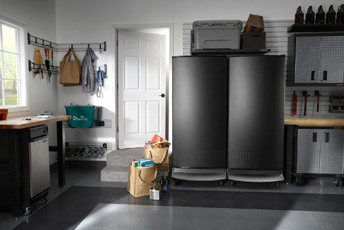 Modern organized garage with stainless-steel garage-ready refrigerator and modular garage cabinets.